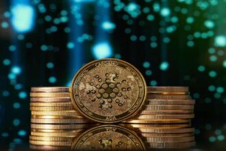 Golden Cardano ADA coin stacked with other coins against blue digital background